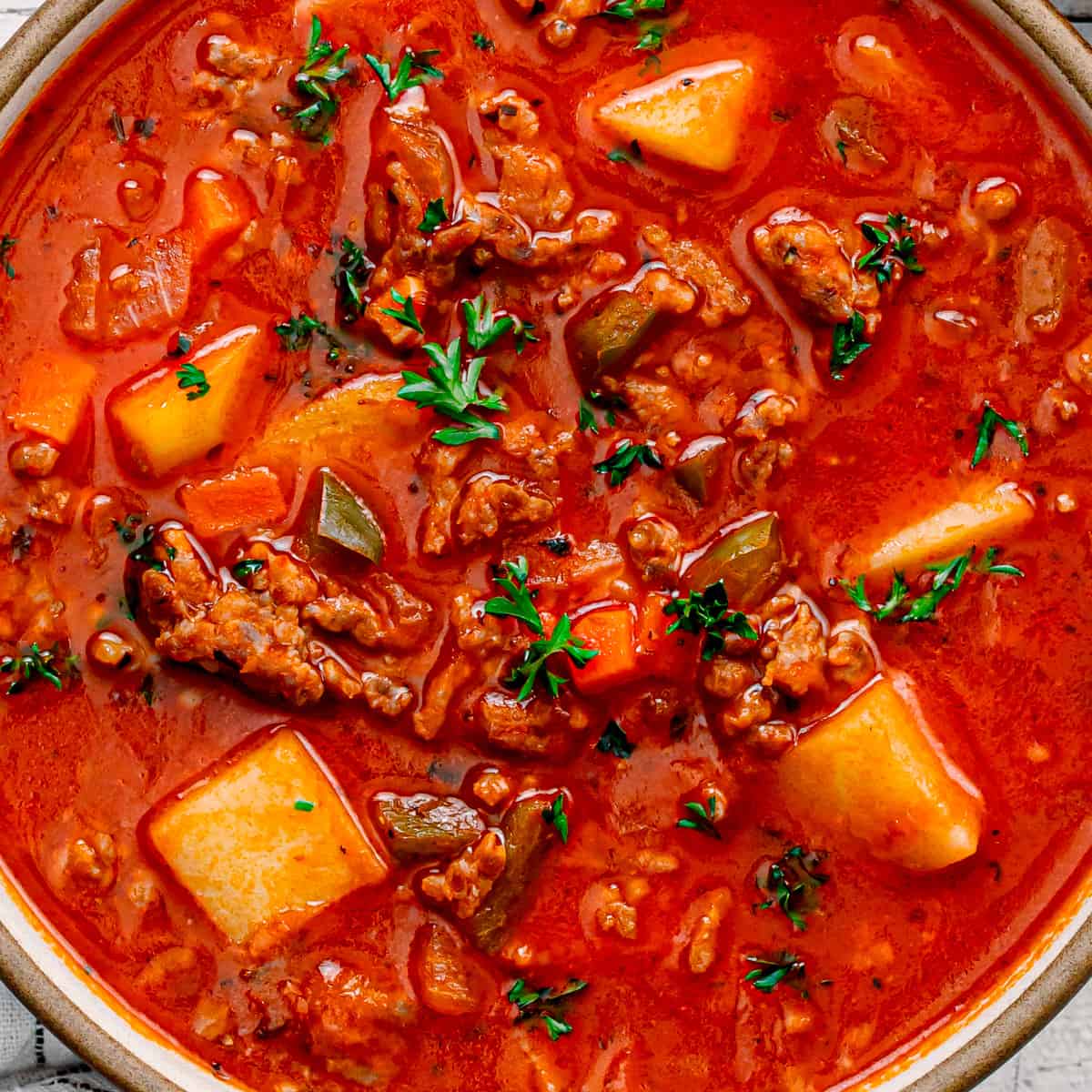 A soup with potato, Italian sausage, vegetables, and tomato broth.