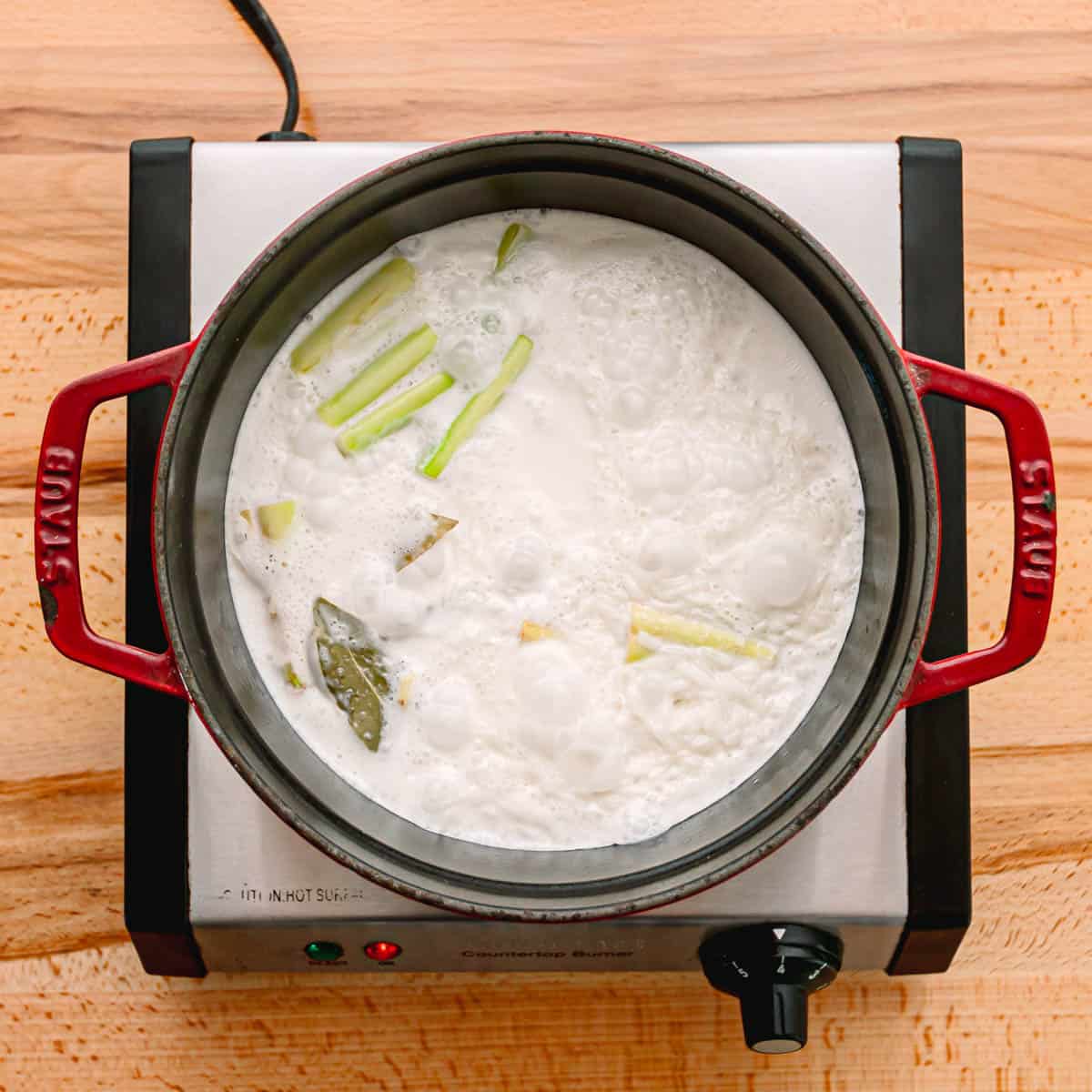 In a saucepan, add rice, coconut milk, water, bay leaf, lemongrass, salt, and sugar. 