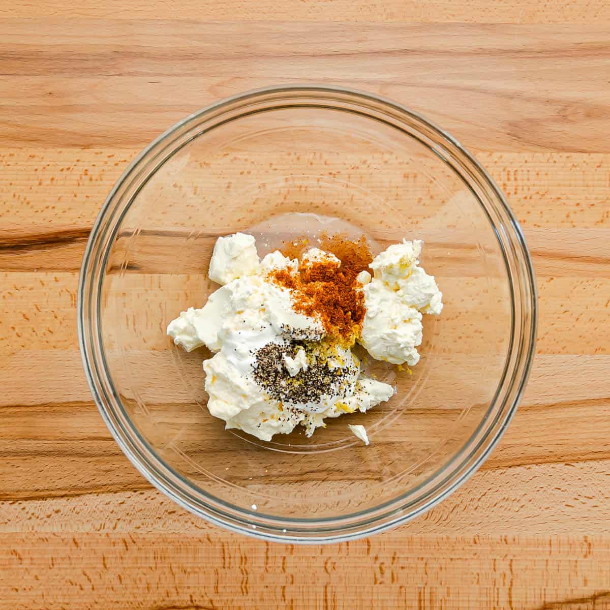In a bowl, combine the cream cheese, mayo, sour cream, salt, black pepper, and Old Bay seasoning until smooth. 