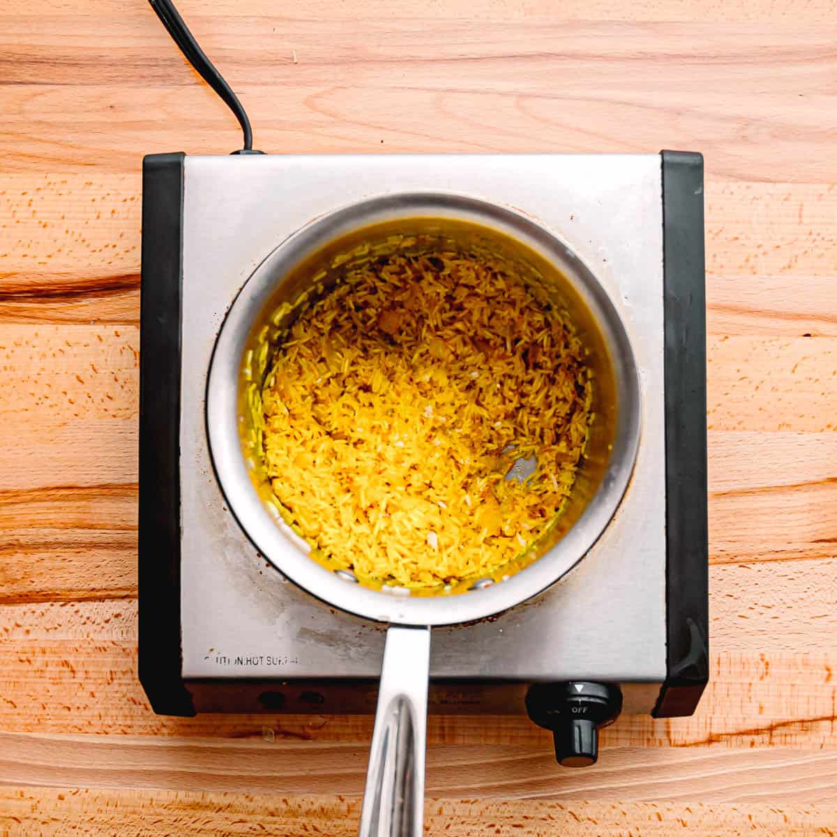 Add turmeric and stir the rice until it is fully coated with turmeric. 