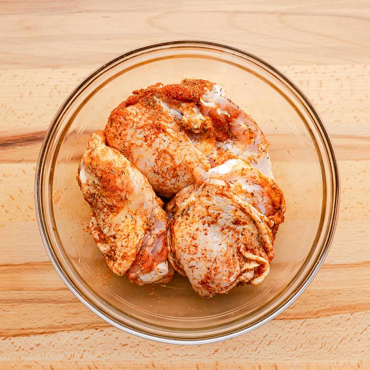 Use paper towels to dry the chicken thighs, then season them all over with smoked paprika, salt, garlic powder, and dried thyme.