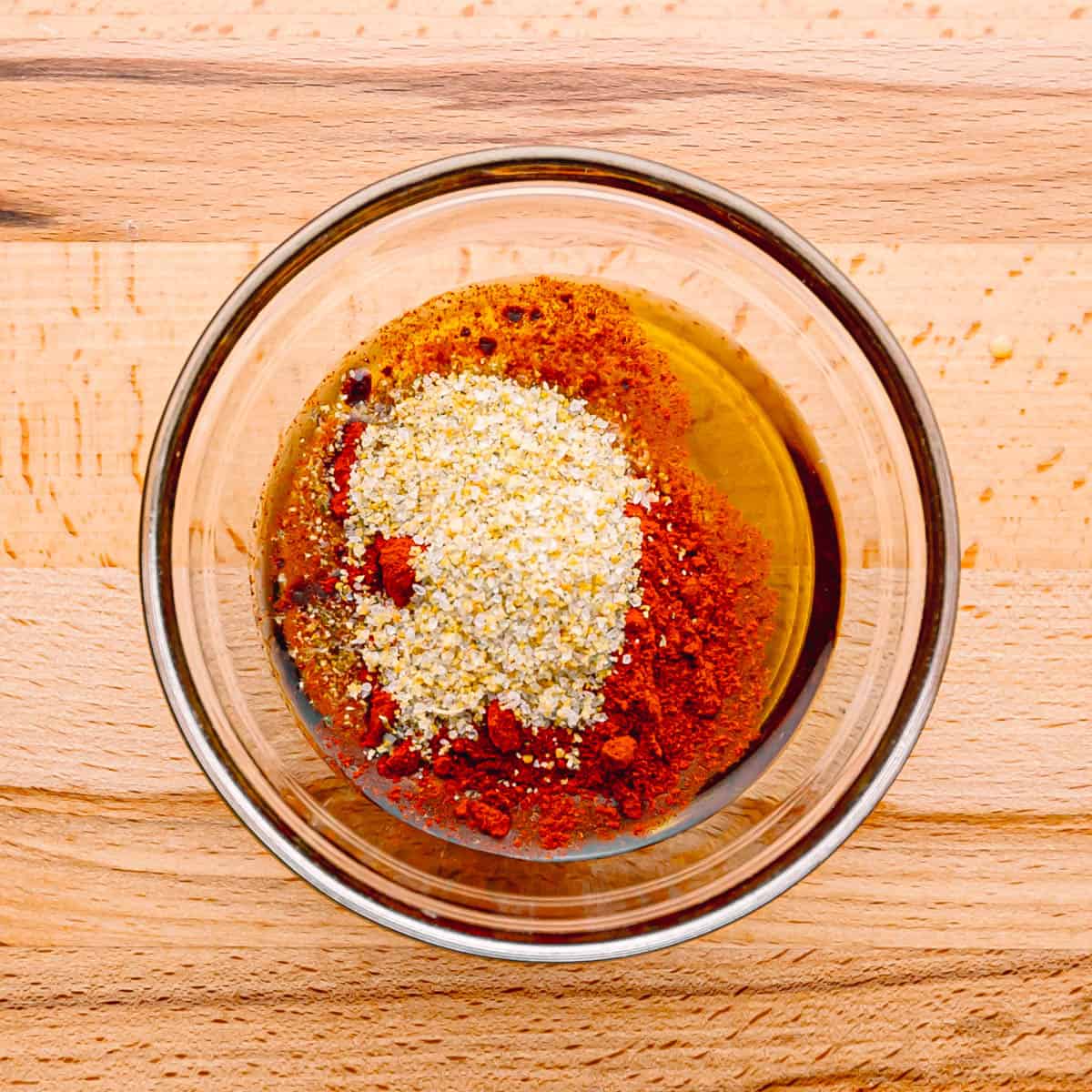 In a mixing bowl, combine the smoked paprika, garlic salt, and olive oil to create a flavorful marinade.