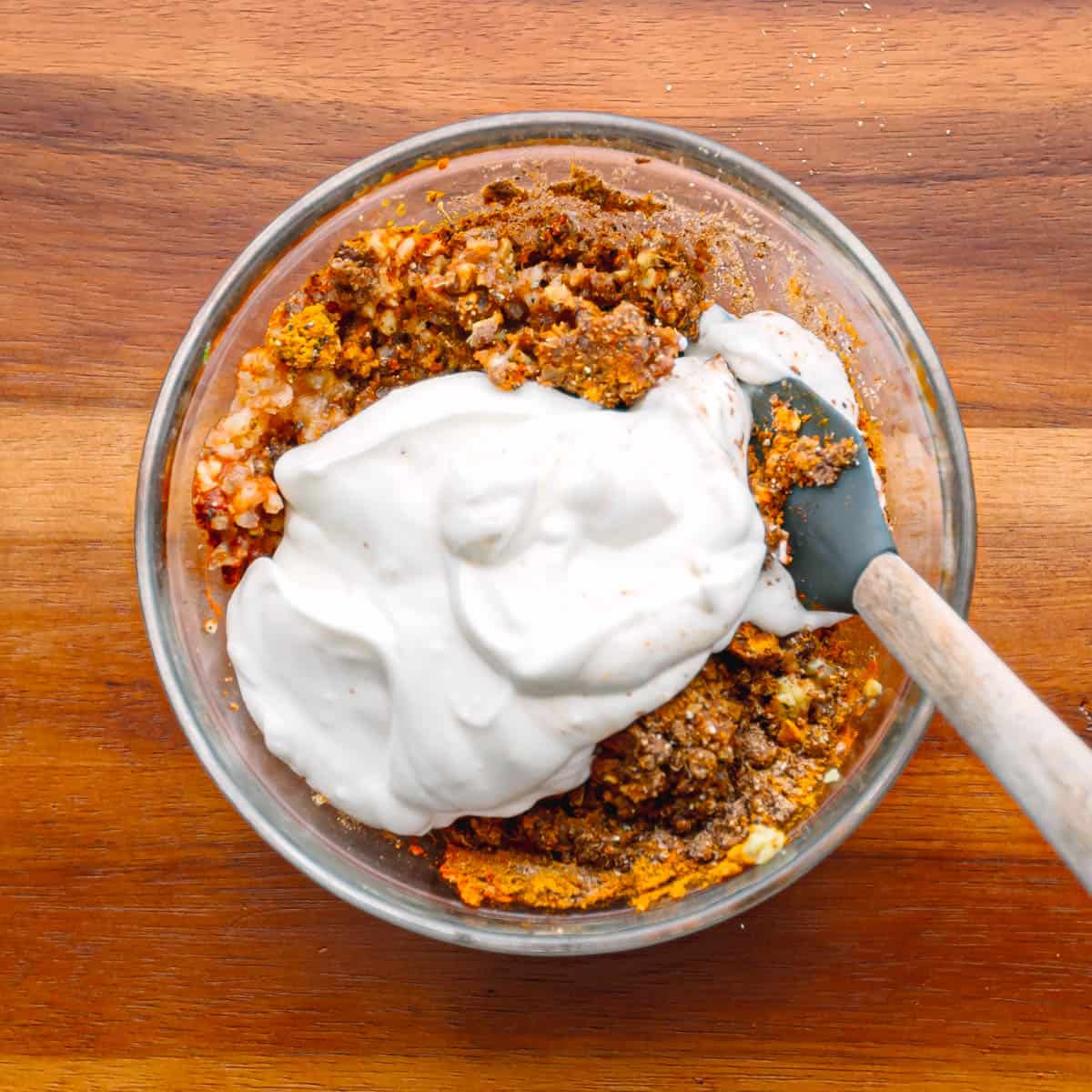 In a food processor, combine yogurt, lemon juice, cumin, turmeric, minced garlic, minced ginger, garam masala, coriander, red chili powder, salt, black pepper, and oil. Puree until smooth.