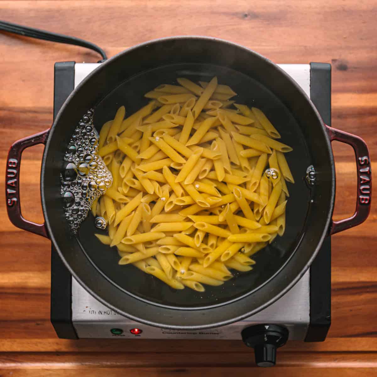 Bring a large pot of water to a boil, then season it with salt. Cook the penne until it's one minute away from being al dente. Reserve at least ¼ cup of pasta water for later.