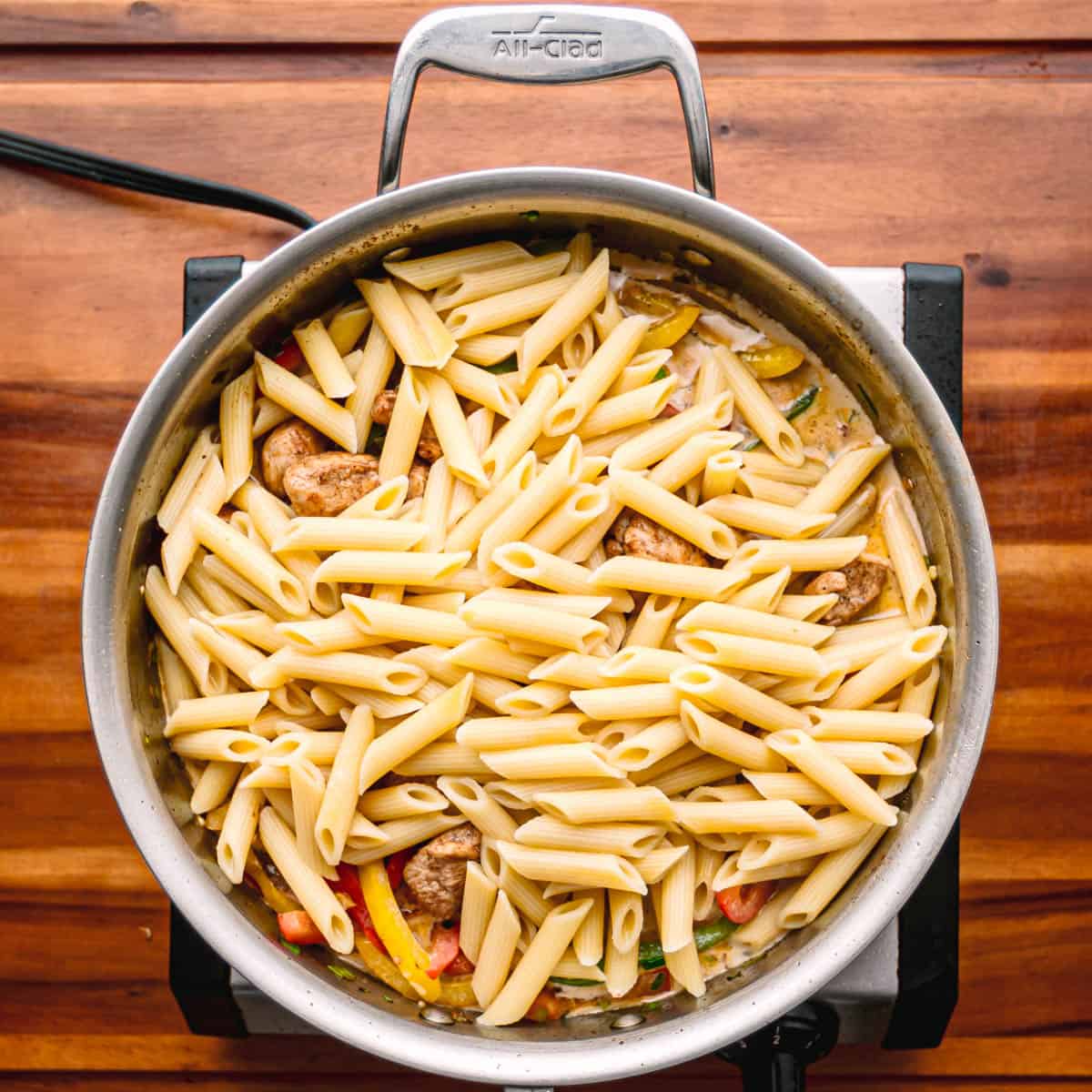 Add the browned chicken, the nearly al dente pasta, and a bit of pasta water to the pan.