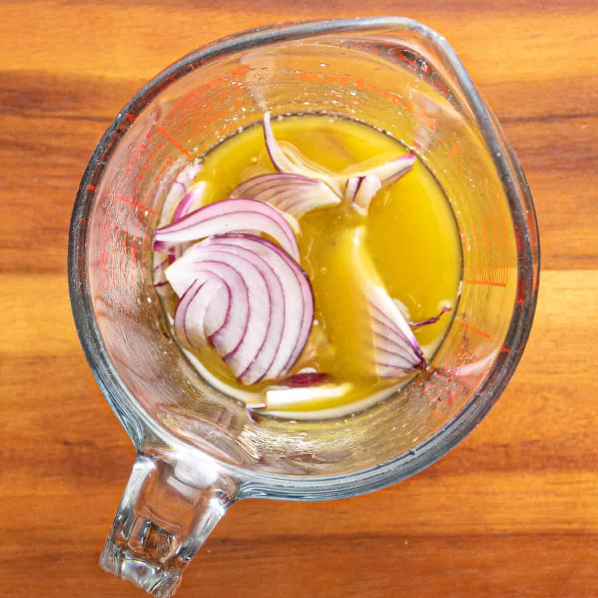 Add the sliced red onion to the dressing and let it sit for a few minutes.