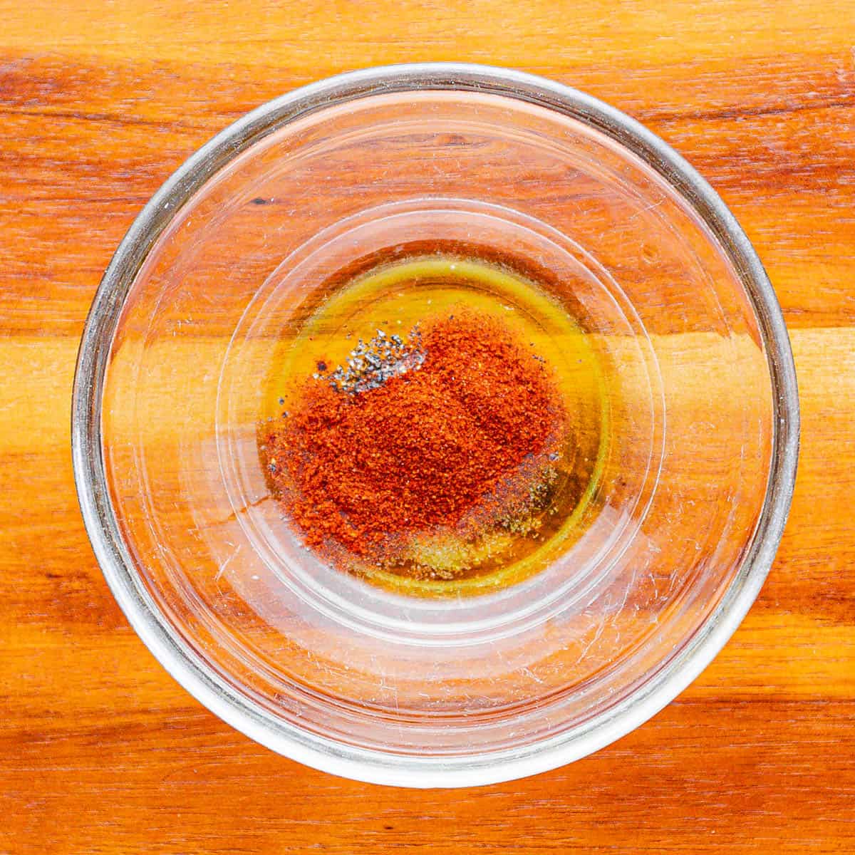 In a small bowl, mix together oil, paprika, salt, and black pepper.