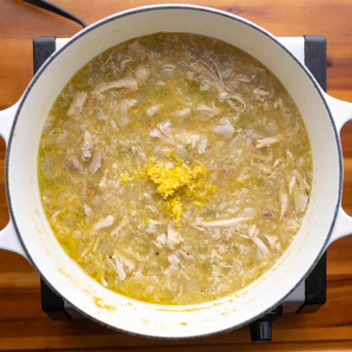 Remove the cooked chicken from the pot and shred it. Add the shredded chicken back to the soup.