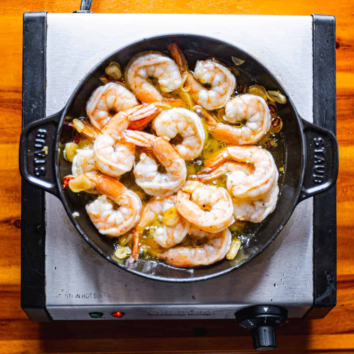 Cook the shrimp over medium heat until they are barely pink, turning often to ensure even cooking.