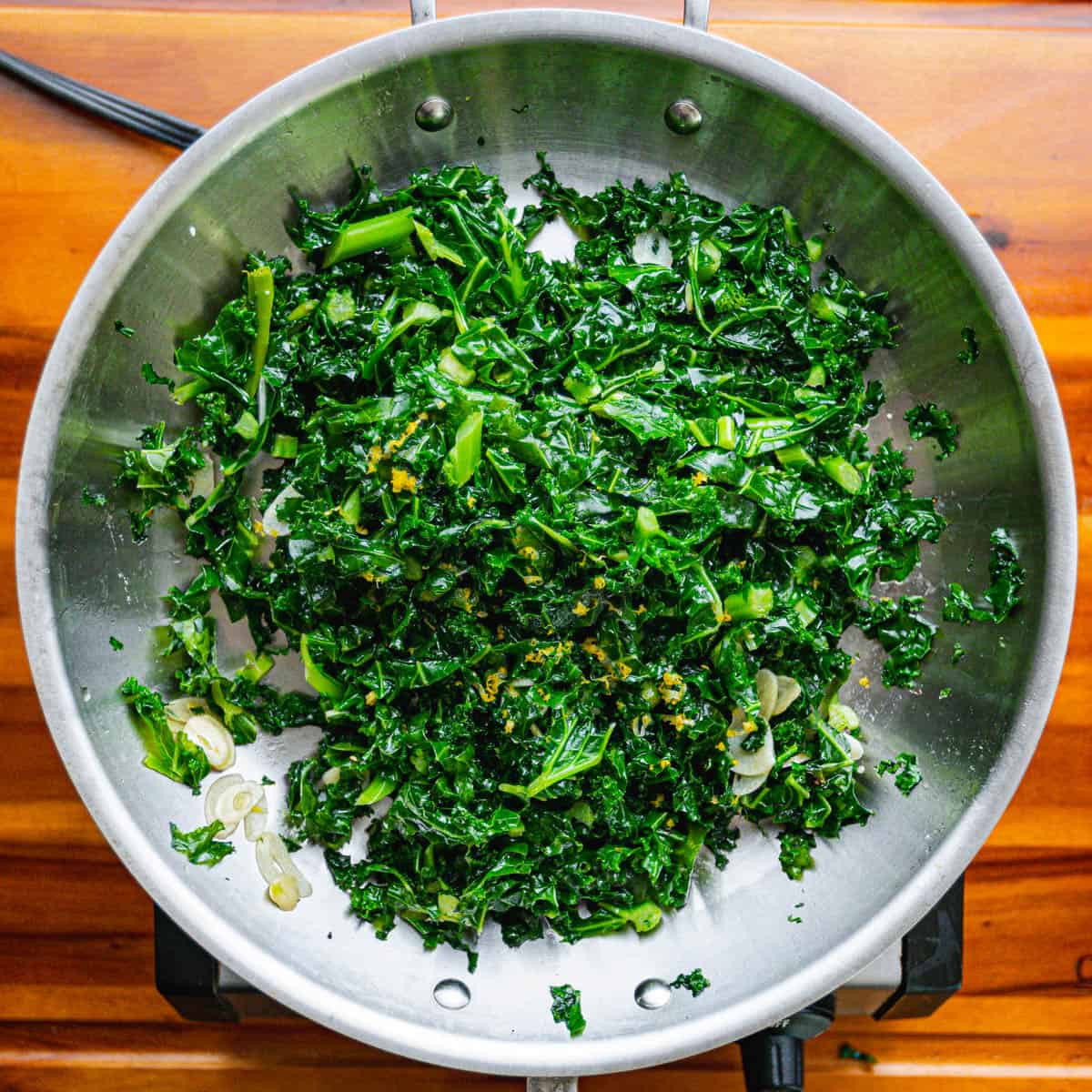 Once the kale reaches your desired level of doneness, transfer it to a serving dish. Sprinkle freshly grated lemon zest over the top.