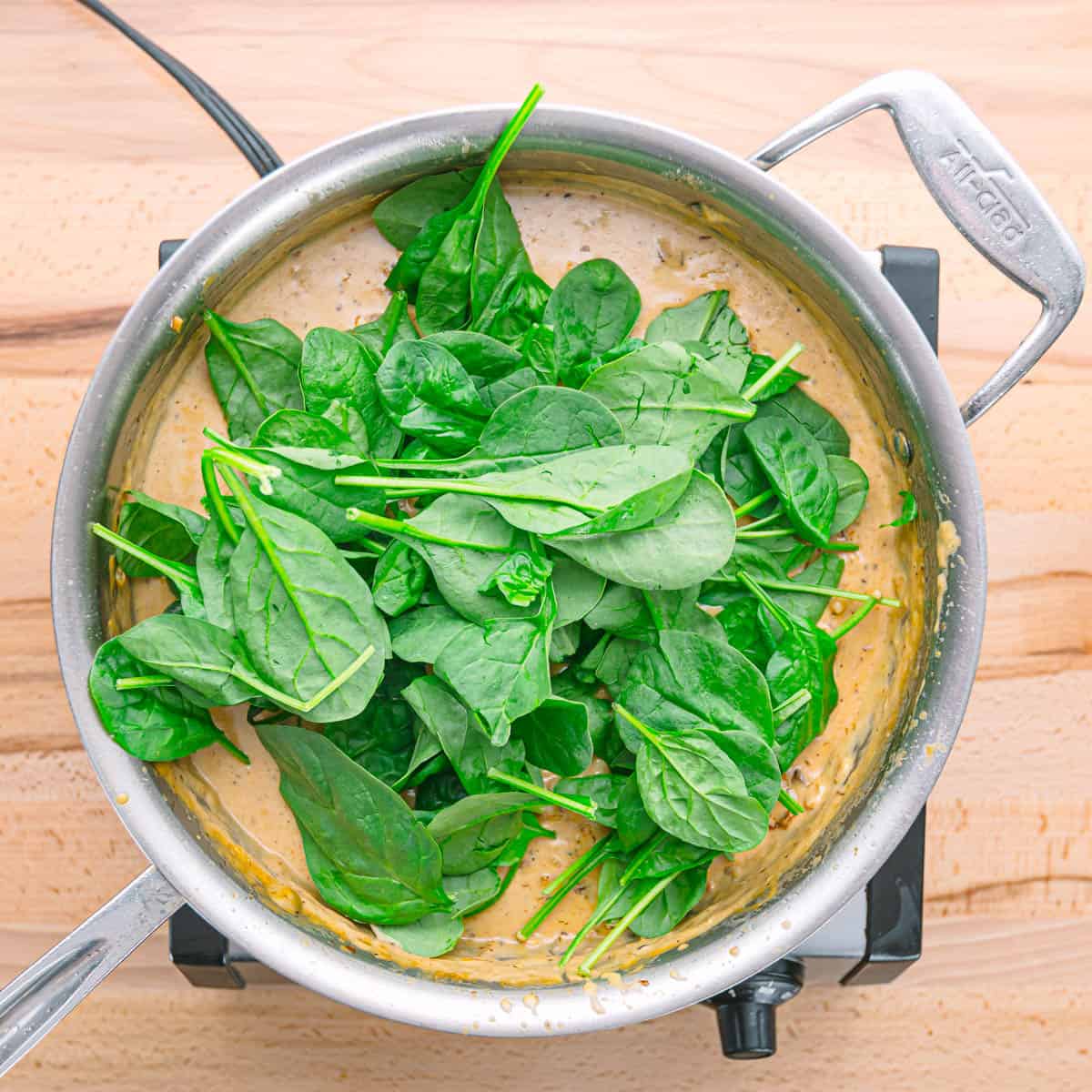 add the fresh spinach to the skillet and cook until it wilts down and becomes tender, stirring occasionally 