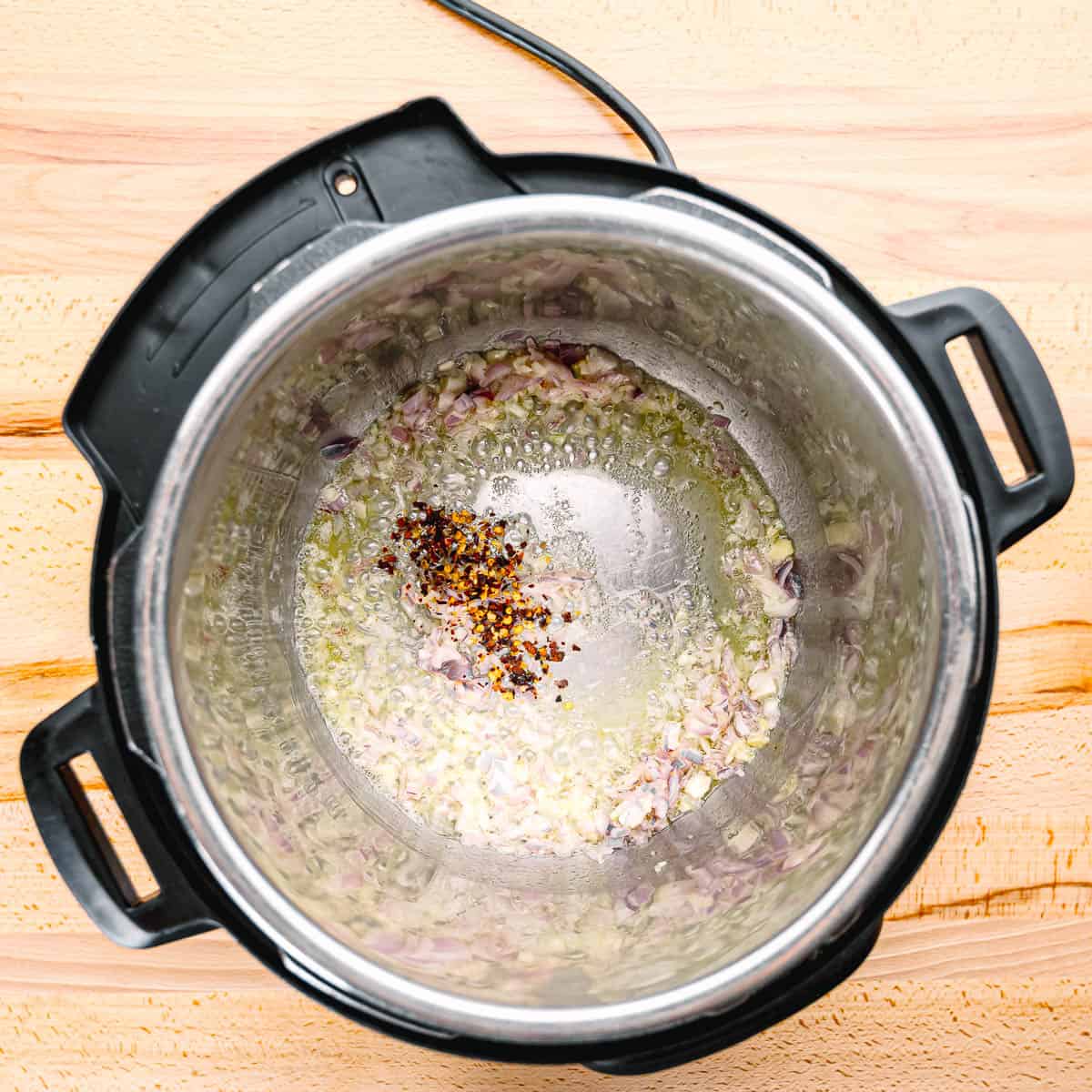 Set the Instant Pot to sauté mode. Melt butter and remaining oil, then sauté shallots, and remaining garlic and red chili pepper flakes until fragrant.