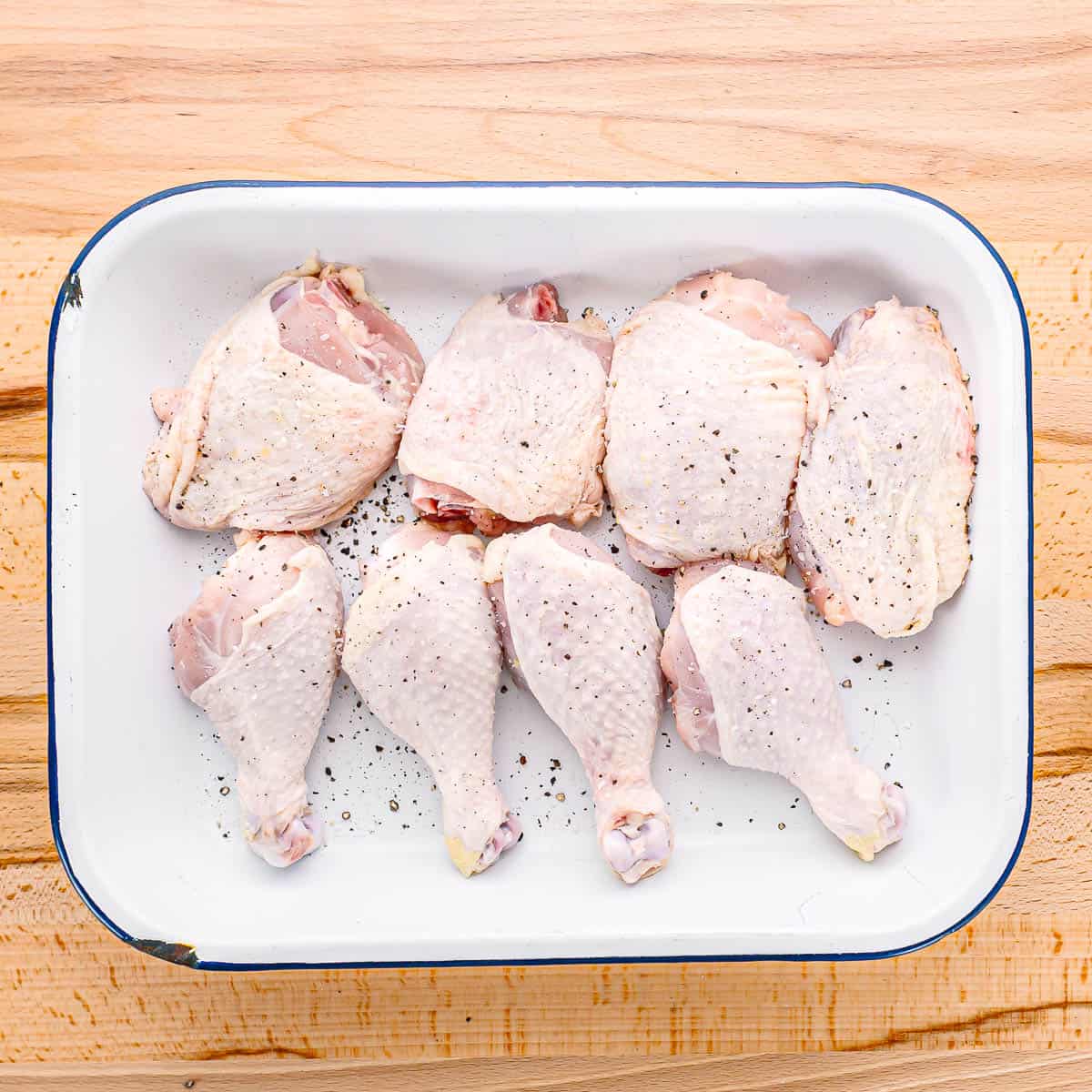 Start by seasoning the chicken legs and thighs with salt and black pepper.