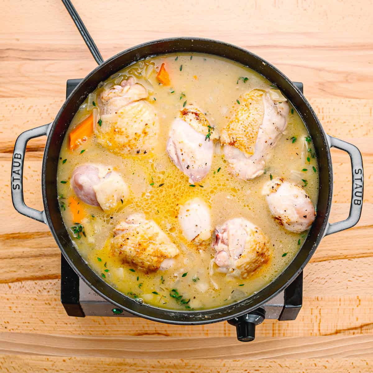 Add the browned chicken back into the pot, along with any juices from the plate. Cover the pot and let it simmer on low-medium heat for about 30 minutes, or until the chicken is cooked through.