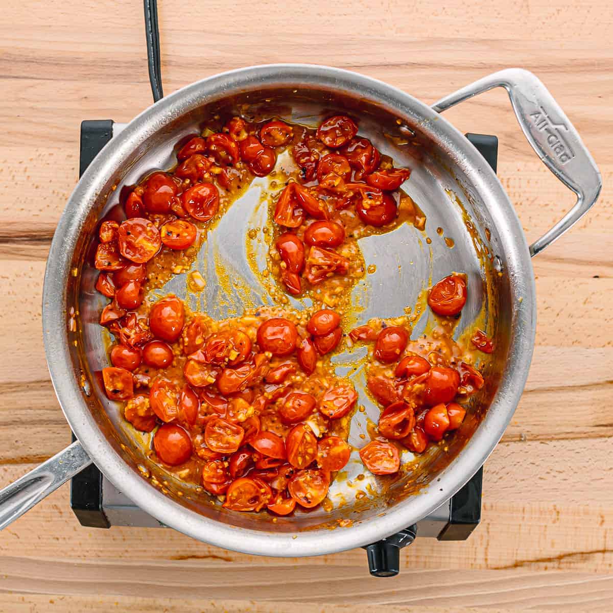 Pour in the dry white wine to deglaze the skillet, scraping up any bits stuck to the bottom. Let the sauce simmer for about 4 minutes, allowing it to reduce.