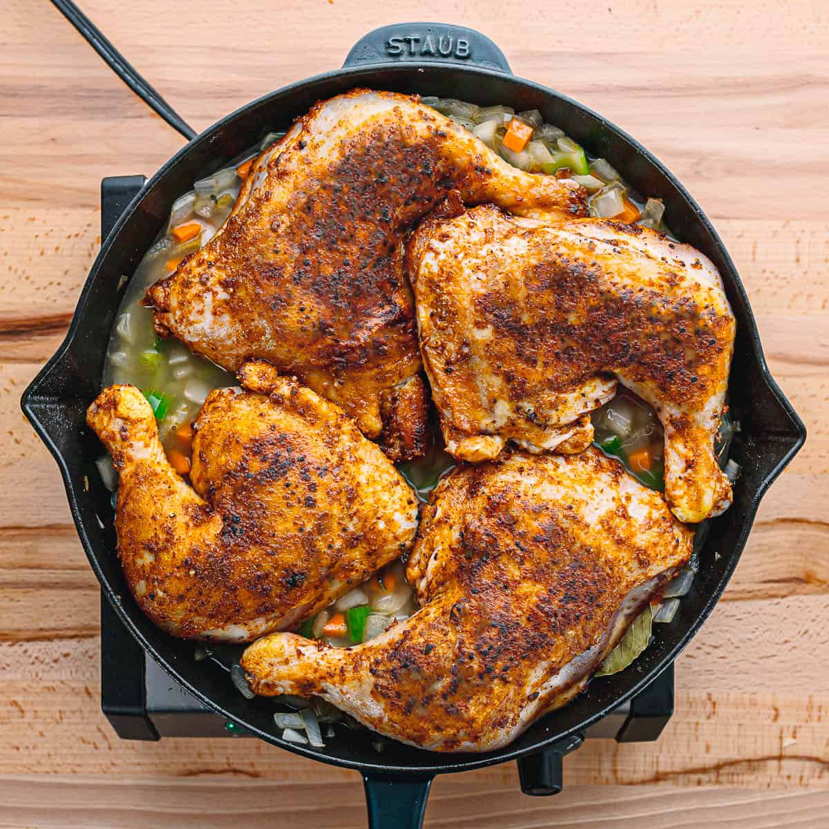 Pour in the broth and return the browned chicken legs to the pot. Bring to a simmer, then transfer the Dutch oven to the preheated oven. 