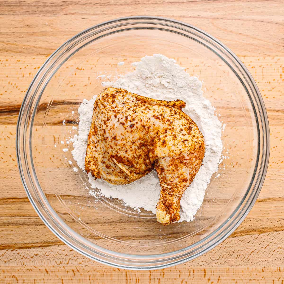 coat the seasoned chicken legs in flour. 