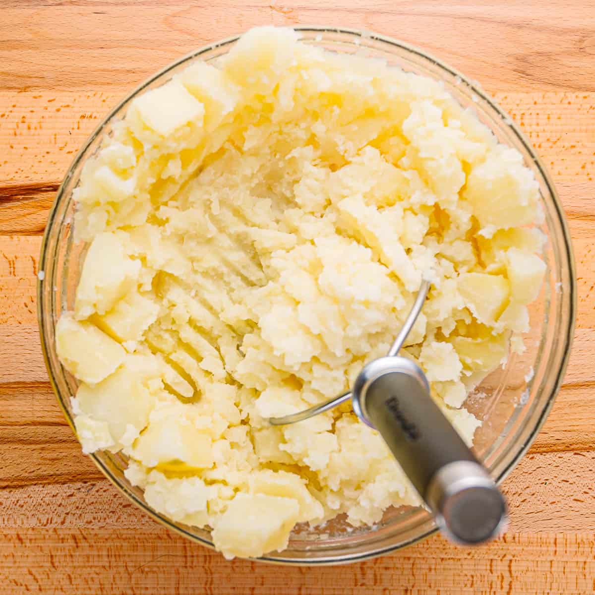 Use a potato masher to mash the potatoes and garlic together. 