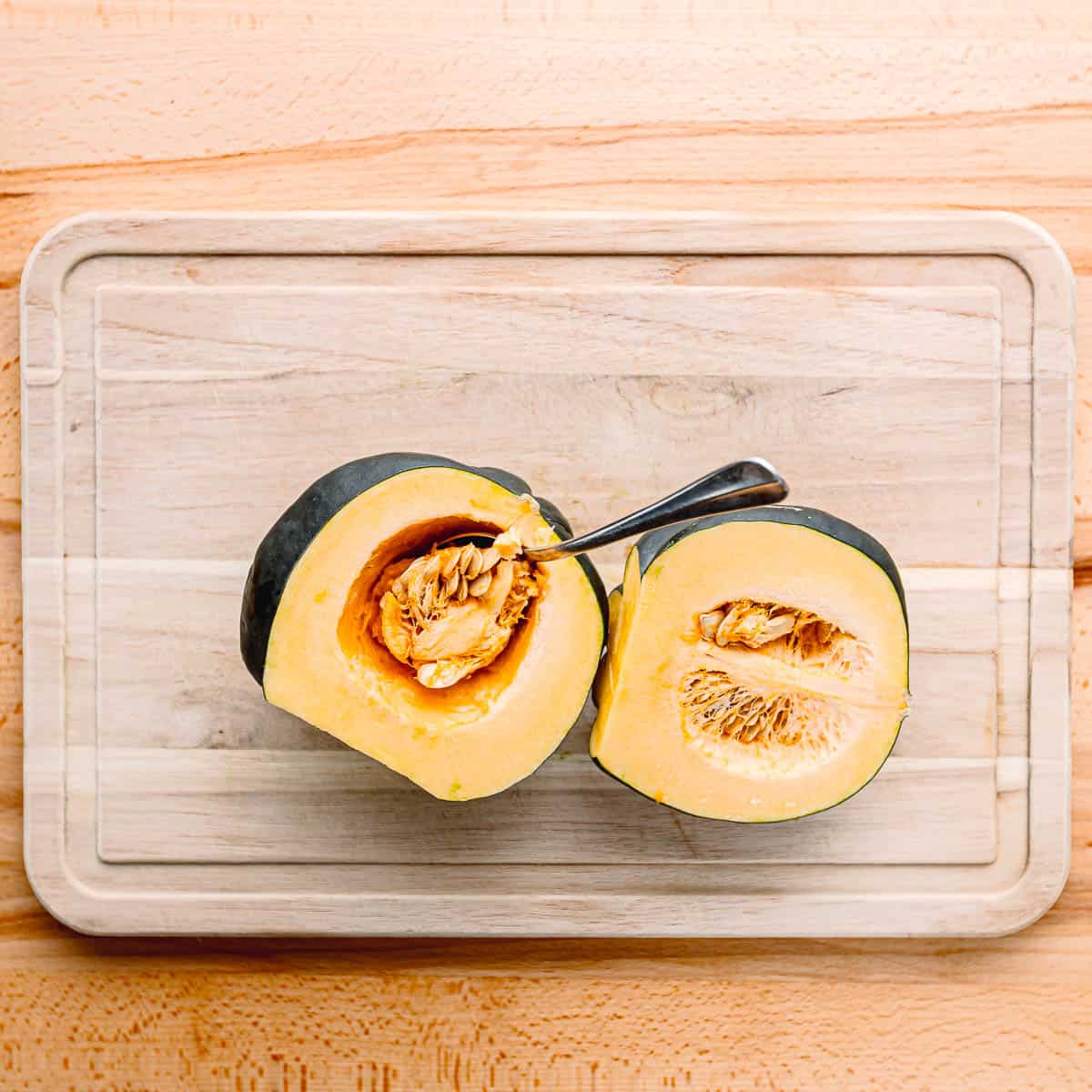 Prepare the Acorn Squash: Start by washing the acorn squash well. Then, using a sharp knife, carefully cut off both ends of the squash. Cut it in half lengthwise and scoop out the seeds with a spoon.