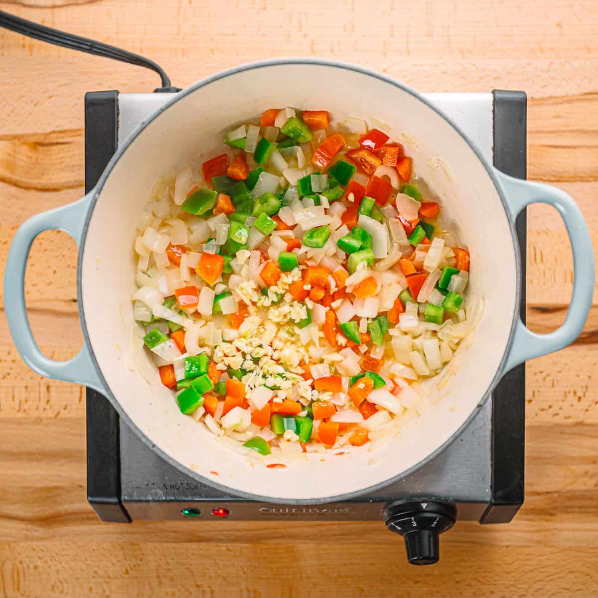 Sautéing onion, bell peppers, and garlic.