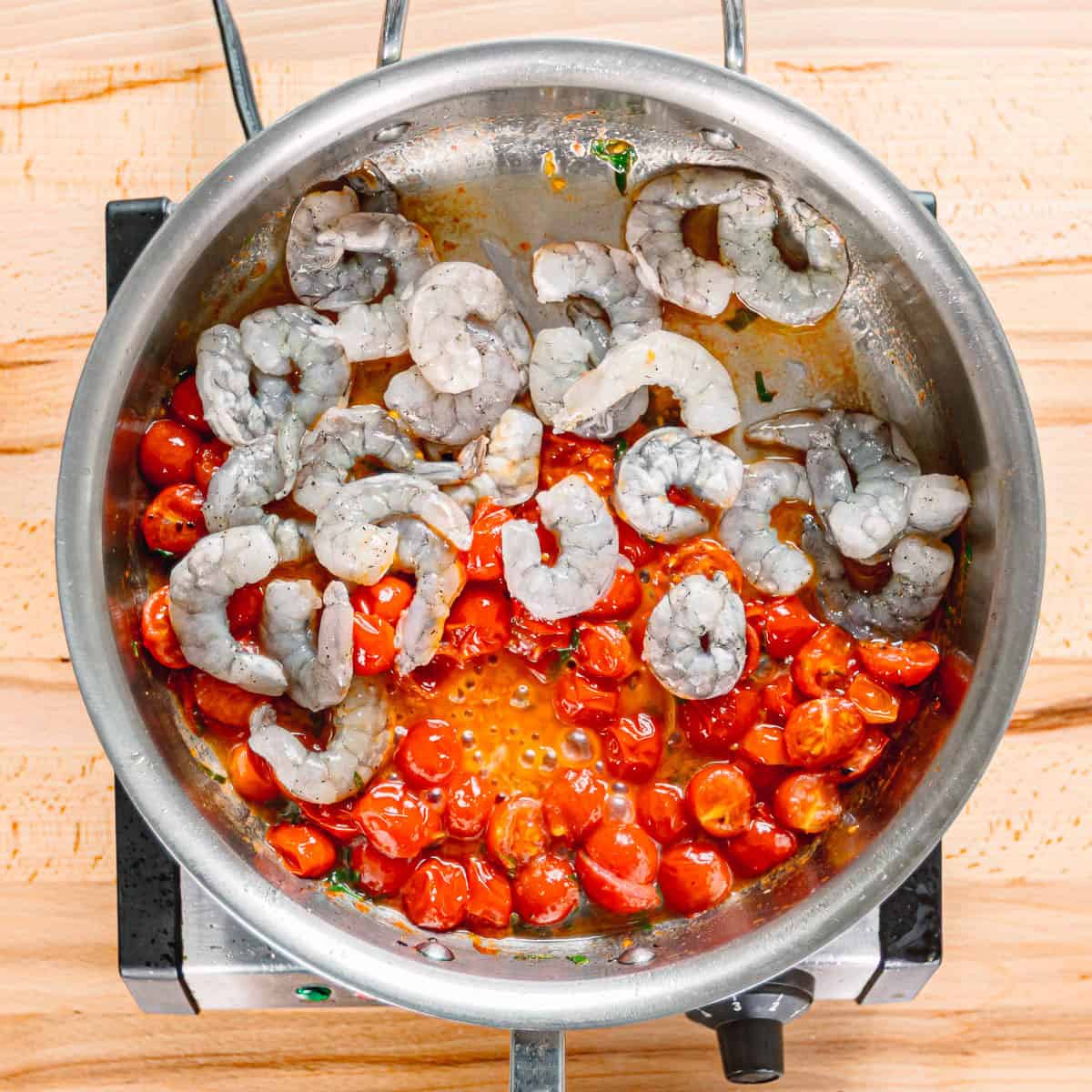 cooking shrimp in tomato sauce.