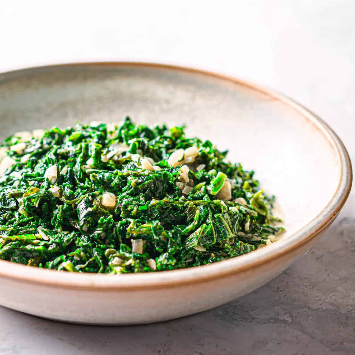 Creamed mustard greens served in a ceramic bowl - easy side dish recipe. 