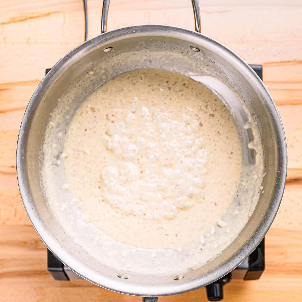 Homemade cream sauce in pot for creamed mustard greens recipe. 