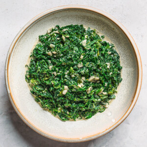 Creamed mustard greens in a bowl with garlic and shallots - rich and savory Southern-style side dish recipe.