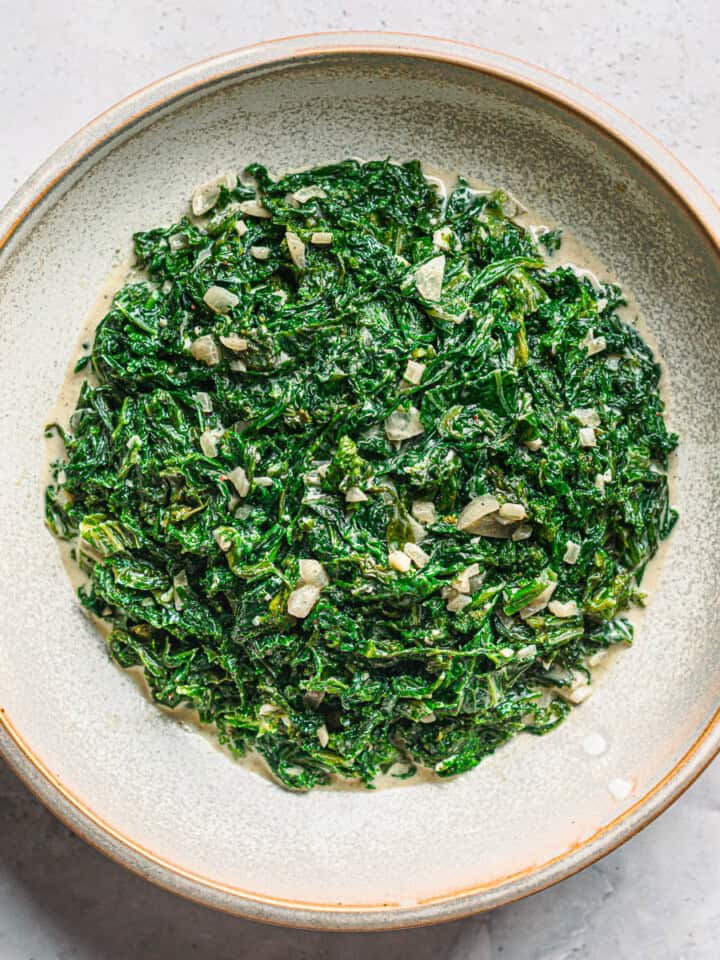 Creamed mustard greens in a bowl with garlic and shallots - rich and savory Southern-style side dish recipe.