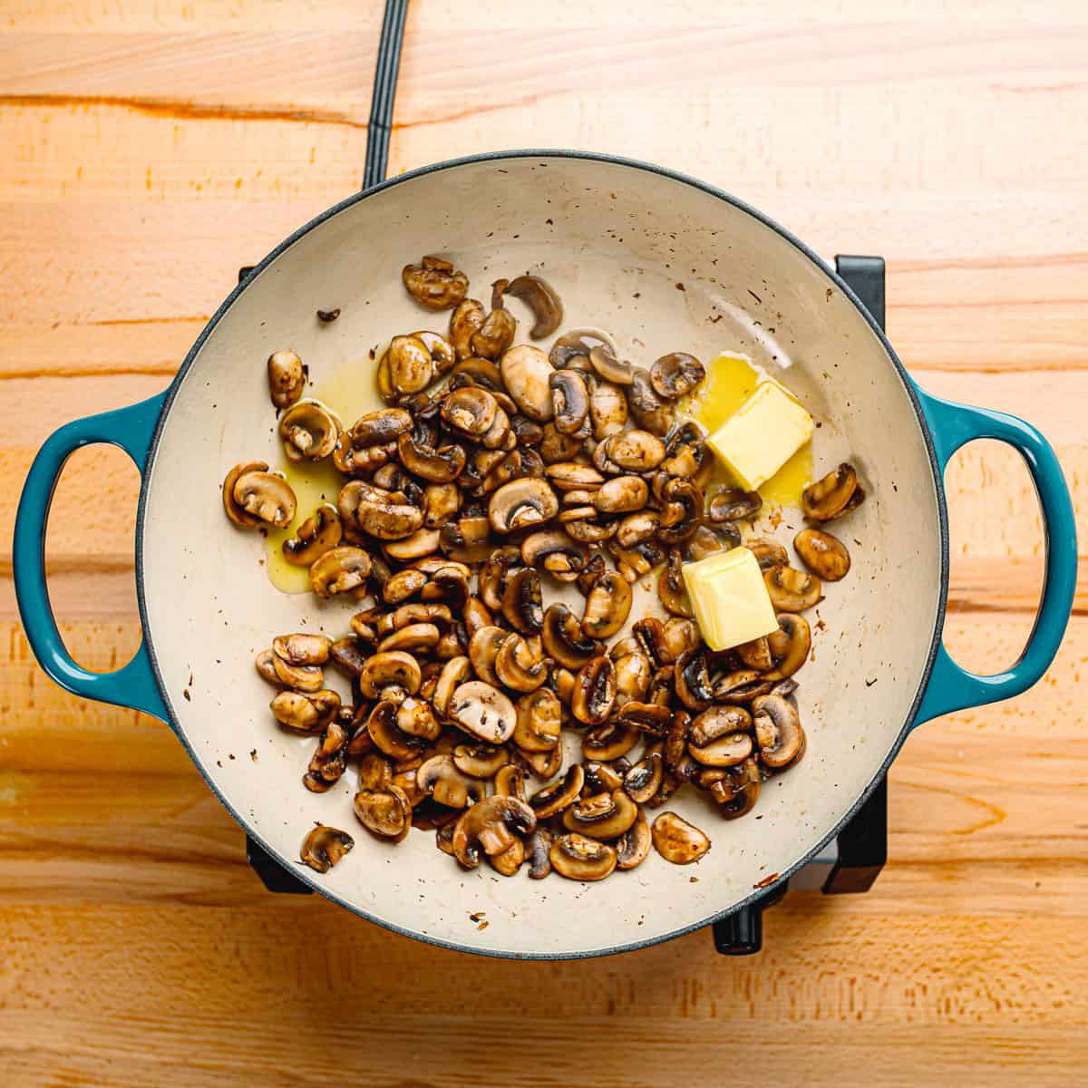 Cooking mushrooms in butter and oil.