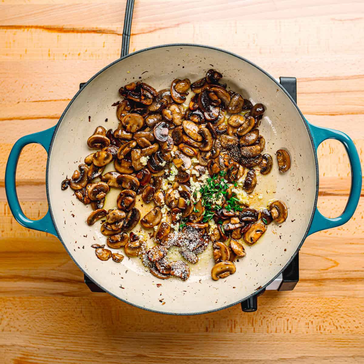 Garlic and thyme added to mushrooms.