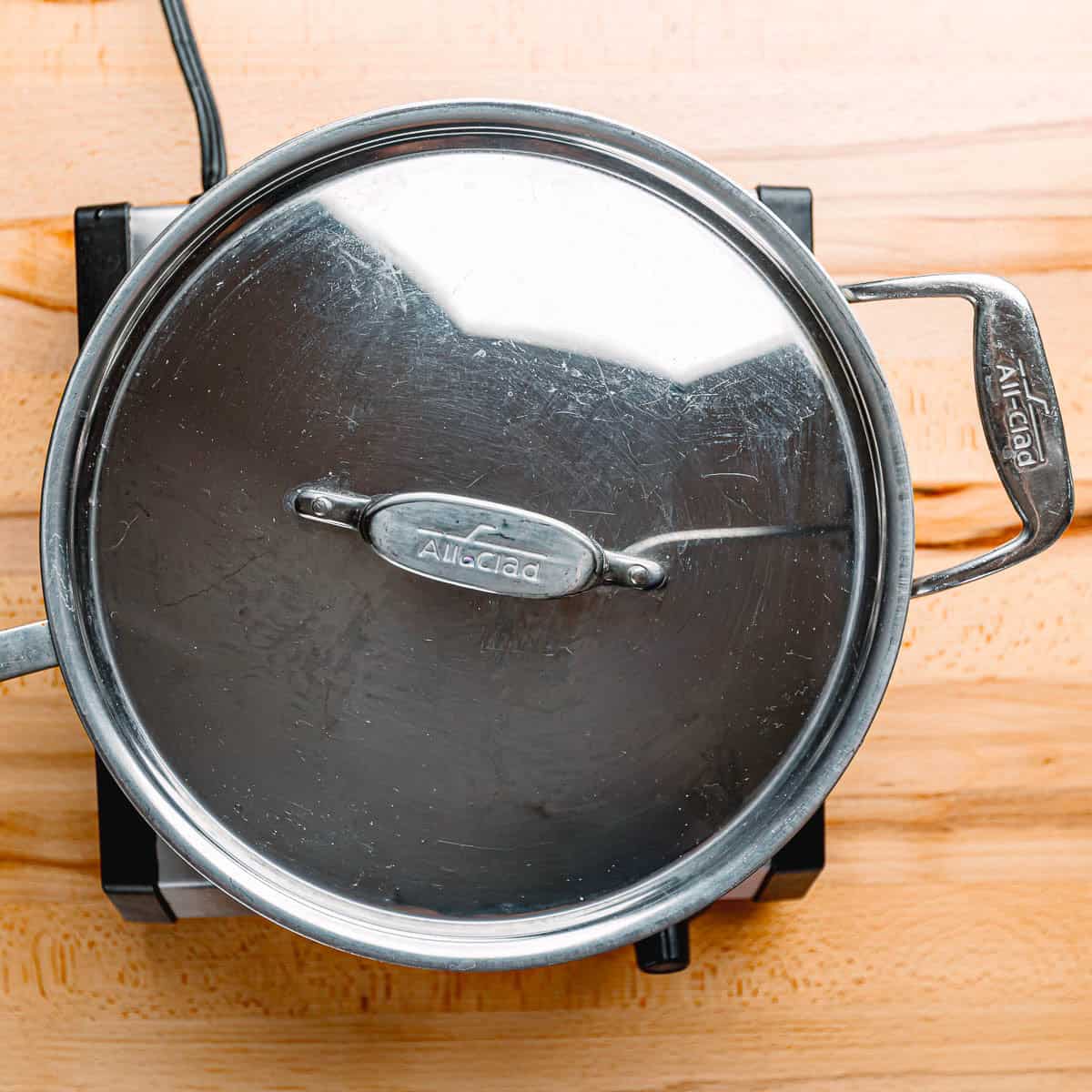 Covering sauté pan of Mexican rice to simmer on low heat.