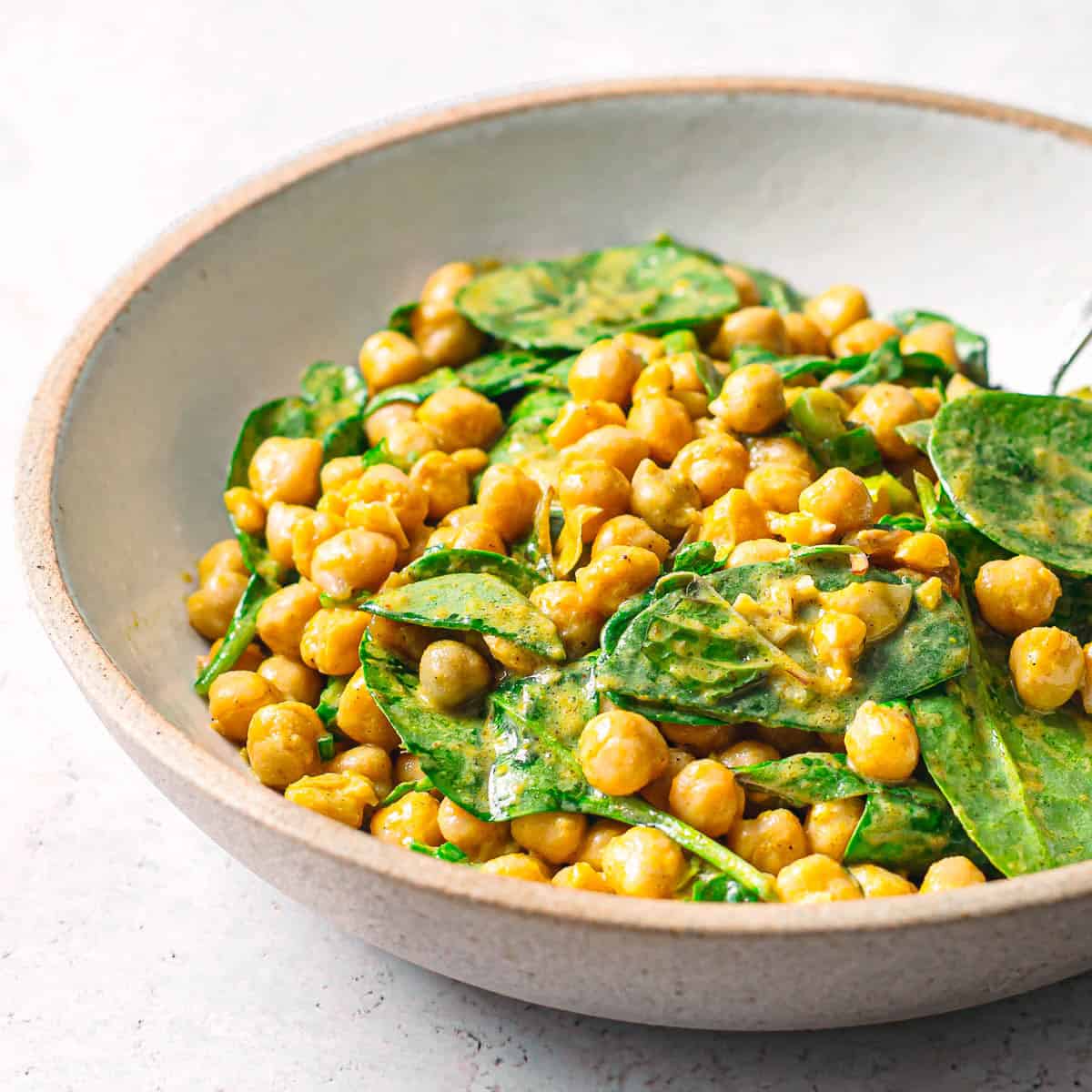 Vegan chickpeas spinach salad with curry mango chutney dressing.