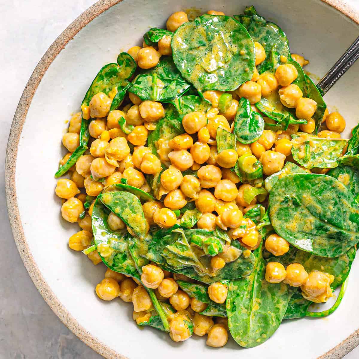 Chickpea spinach salad with sweet and tangy curry dressing.