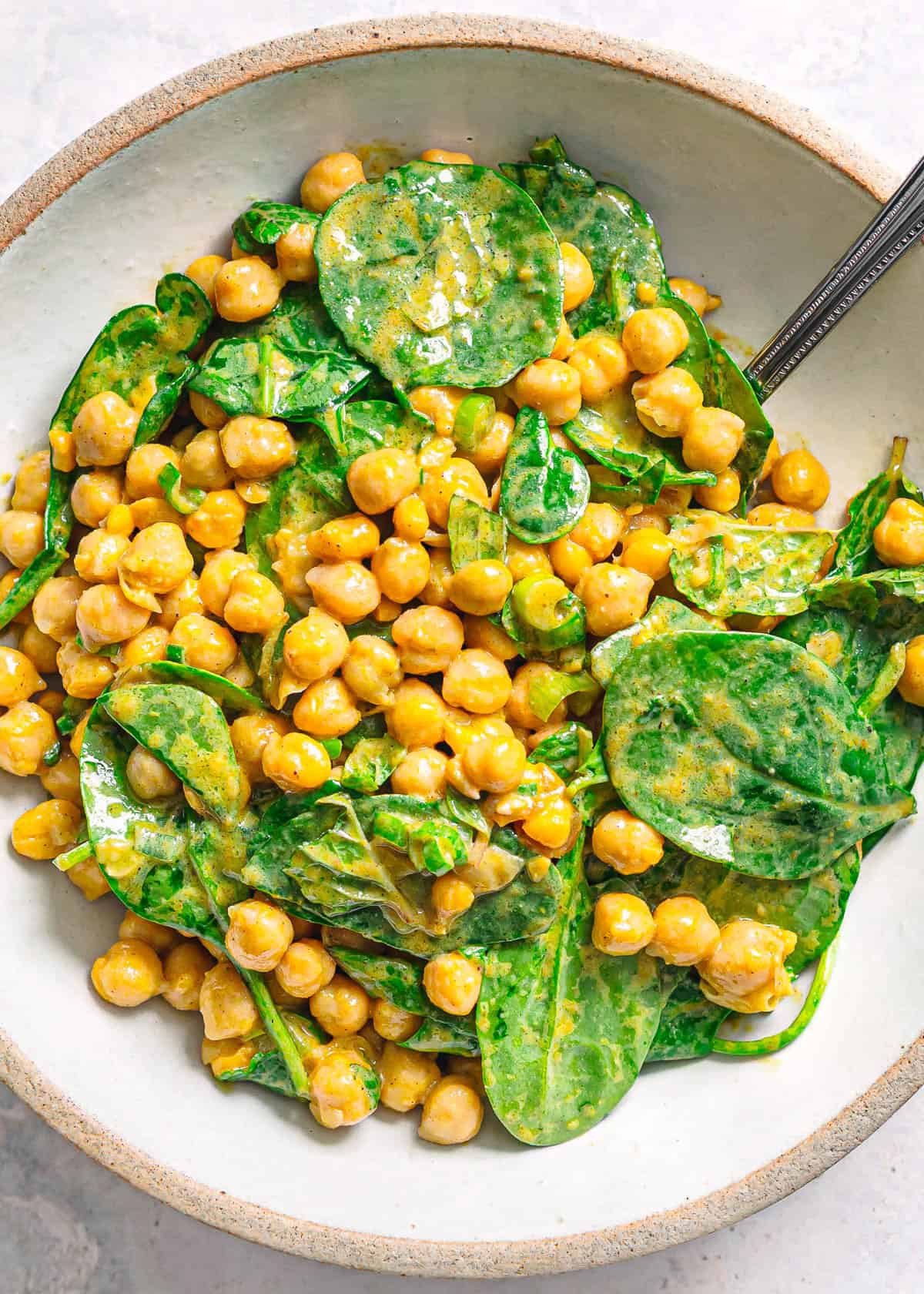 Healthy spinach and chickpea salad with curry vinaigrette.
