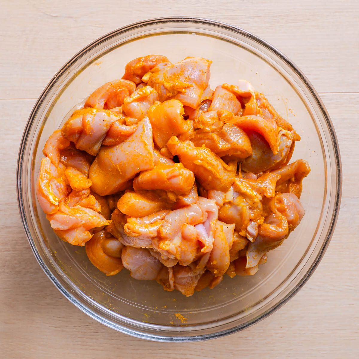 Chicken Jalfrezi chicken marinating with spices in a bowl.