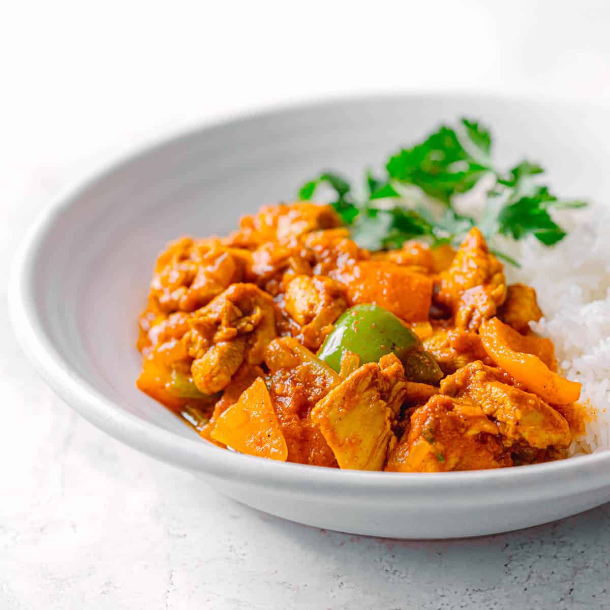 Chicken Jalfrezi in white bowl shown from side angle.