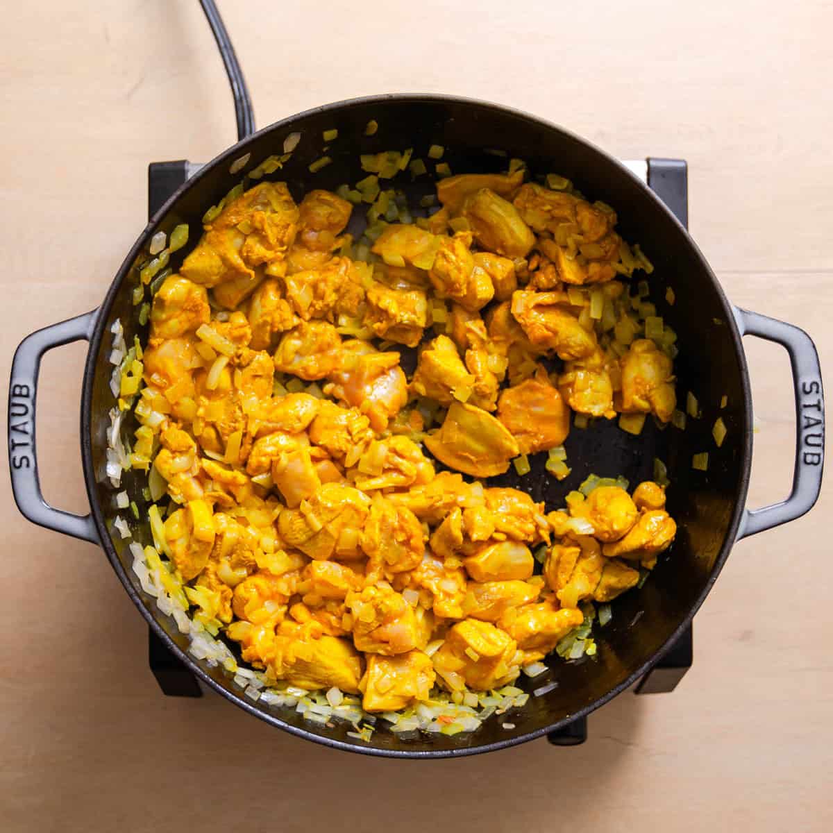 Garlic, ginger, and spices added to Chicken Jalfrezi mixture.