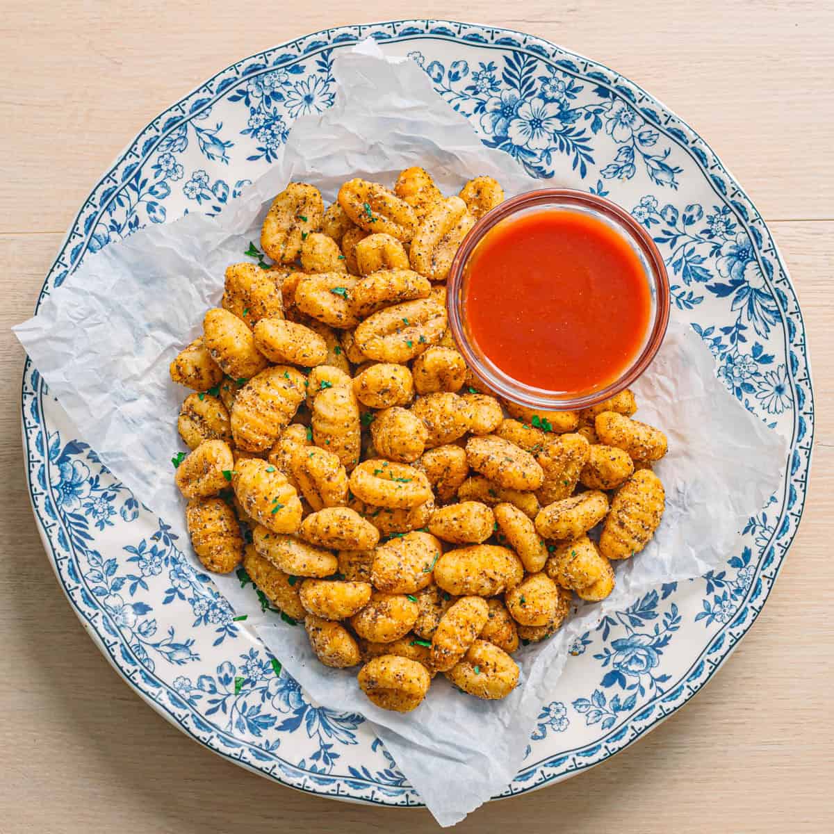 Air fryer gnocchi served in a ceramic bowl with marinara sauce.