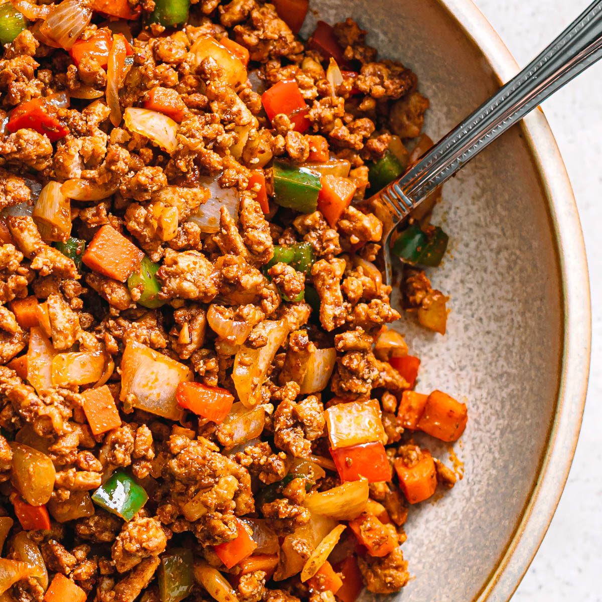 Bowl of easy ground chicken stir fry with seasoned chicken and vegetables.