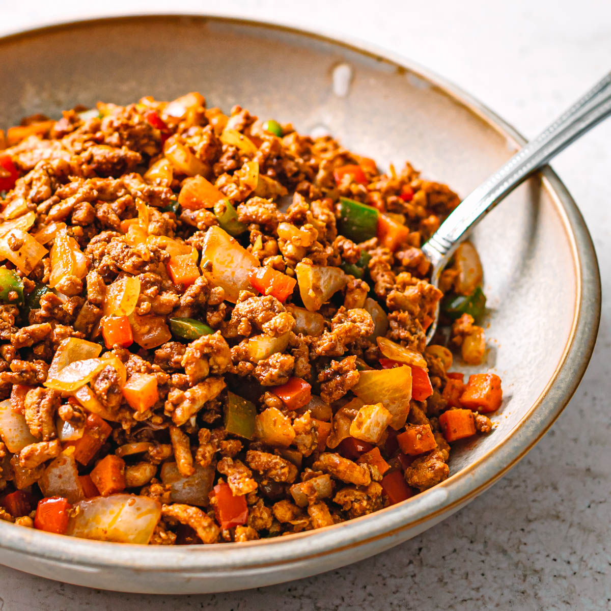 Close-up of easy ground chicken stir fry served in a ceramic bowl.