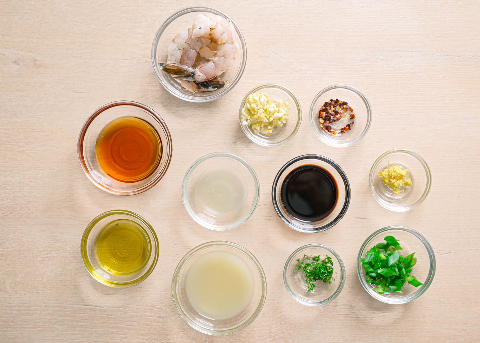 Honey garlic shrimp ingredients on table with raw shrimp, honey, garlic, soy sauce, and seasoning for easy seafood recipe.