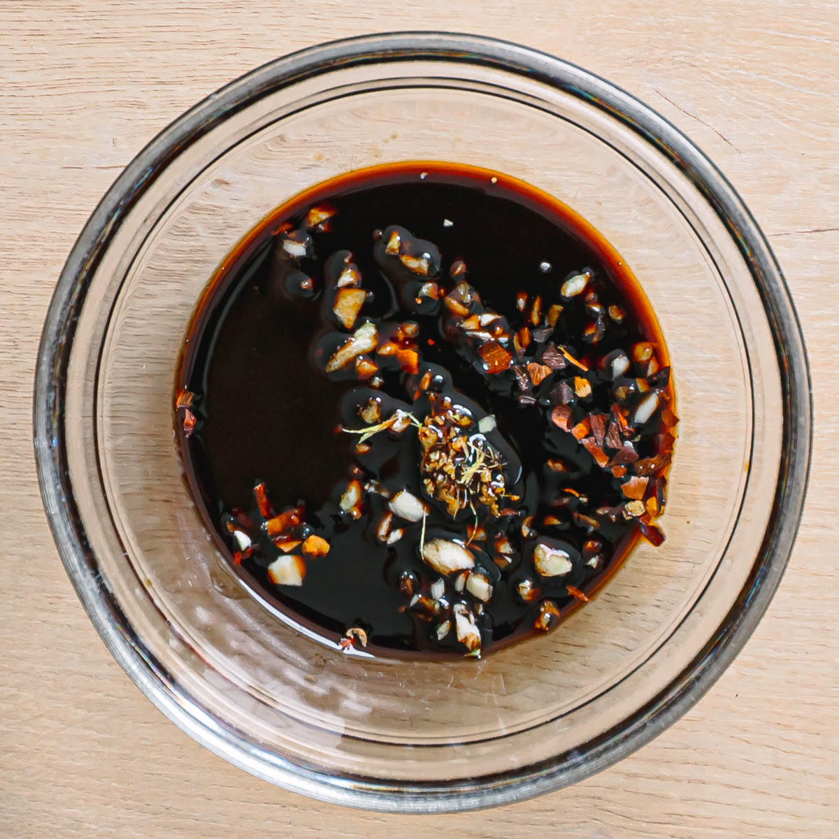 Mixing honey garlic sauce in bowl with soy sauce and garlic for shrimp recipe marinade.