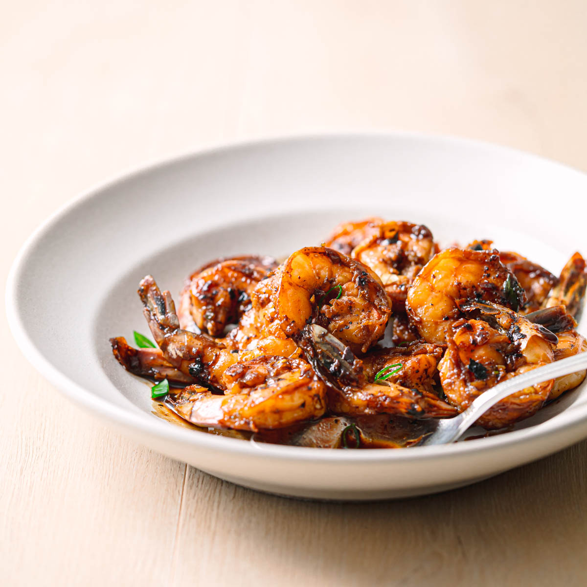 Honey soy garlic shrimp in serving bowl with rich sticky sauce.