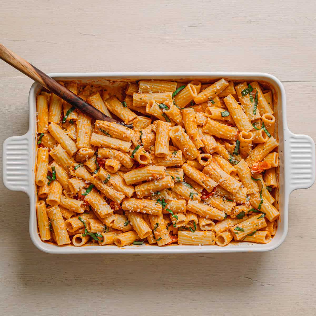 Finished Boursin tomato pasta with roasted cherry tomatoes and melted Boursin cheese still in baking dish.
