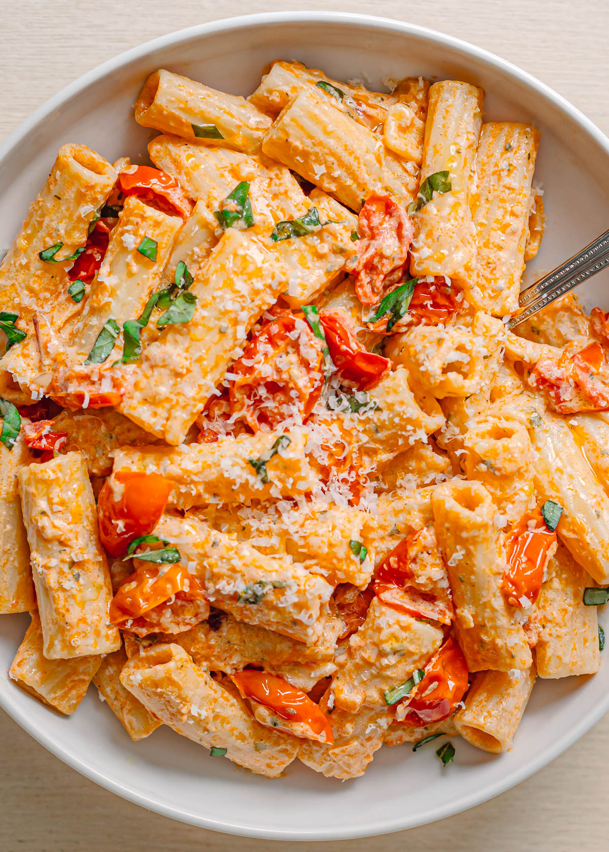 Boursin tomato pasta with blistered tomatoes and herbs in rustic ceramic bowl.