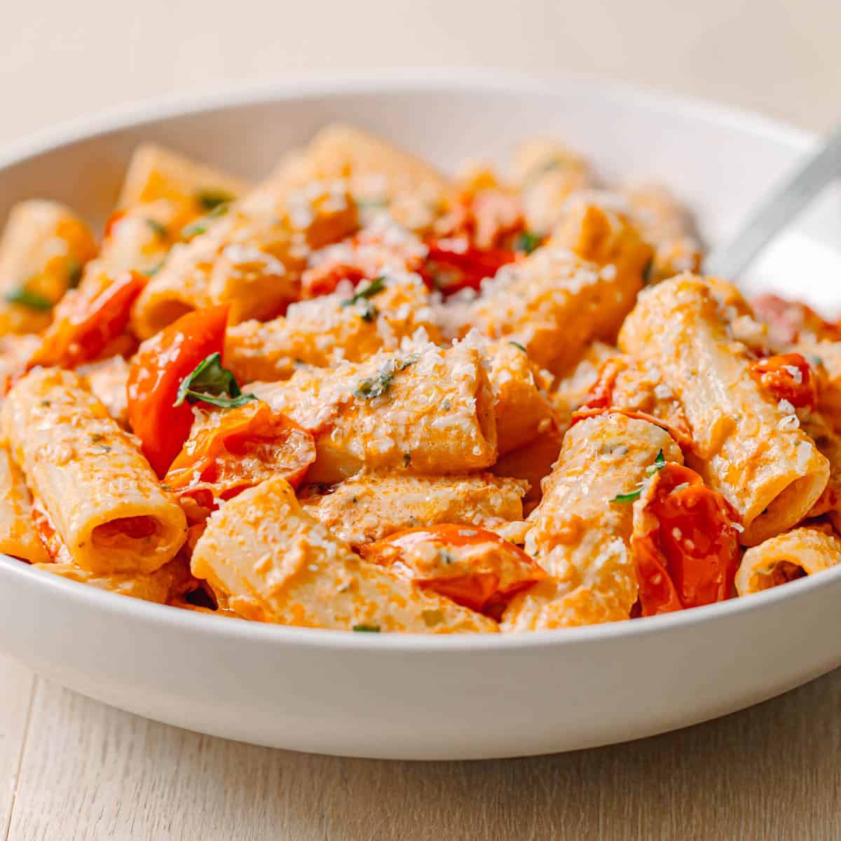 Tasty Boursin tomato pasta. Creamy roasted tomato and Boursin pasta with rigatoni and basil garnish.