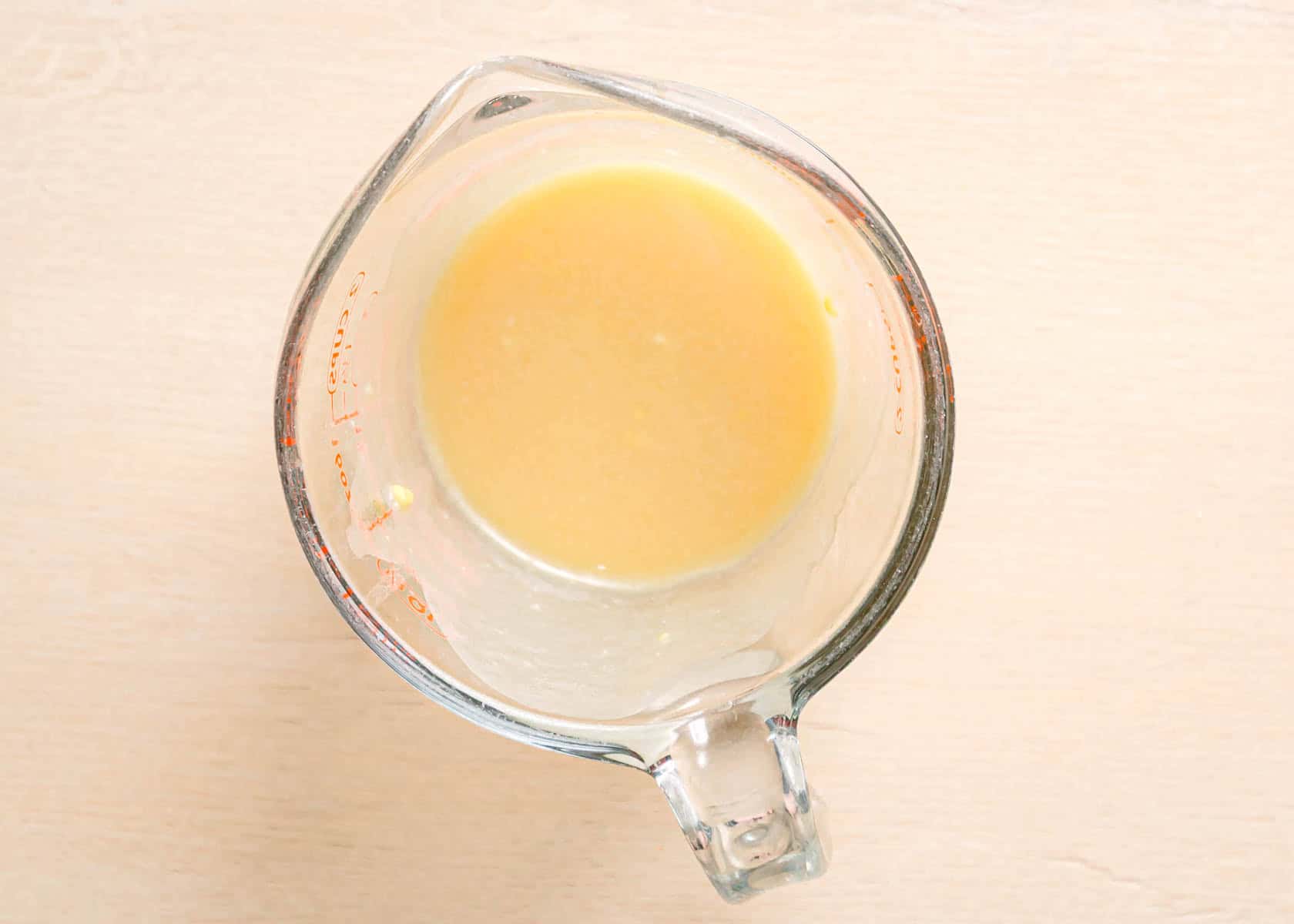 Easy miso salad dressing recipe drizzling avocado oil into miso mixture while whisking.