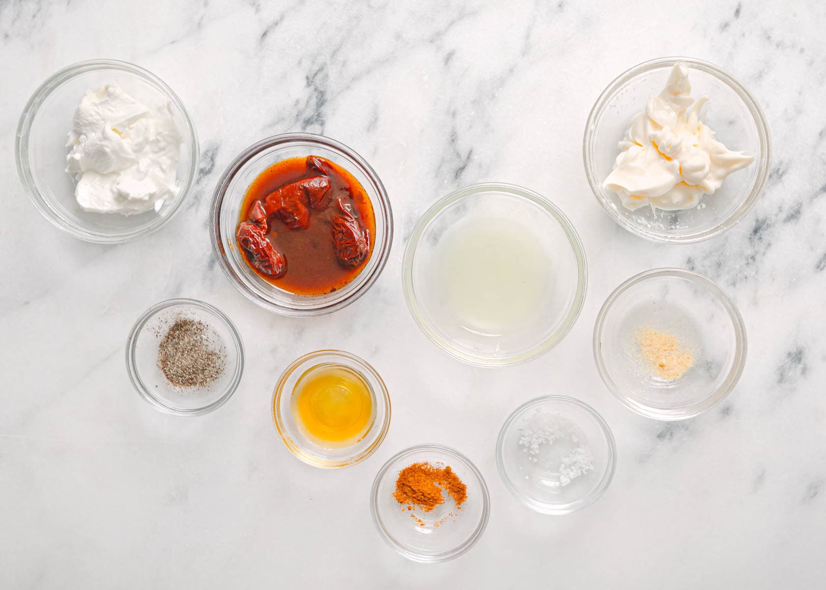 : Ingredients for creamy chipotle sauce including mayo, sour cream, chipotle peppers, and lime.