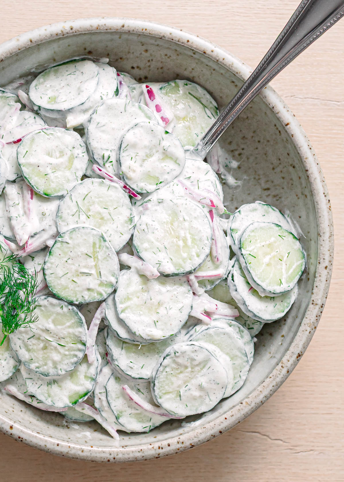 Overhead shot of cucumber dill salad in a serving bowl.